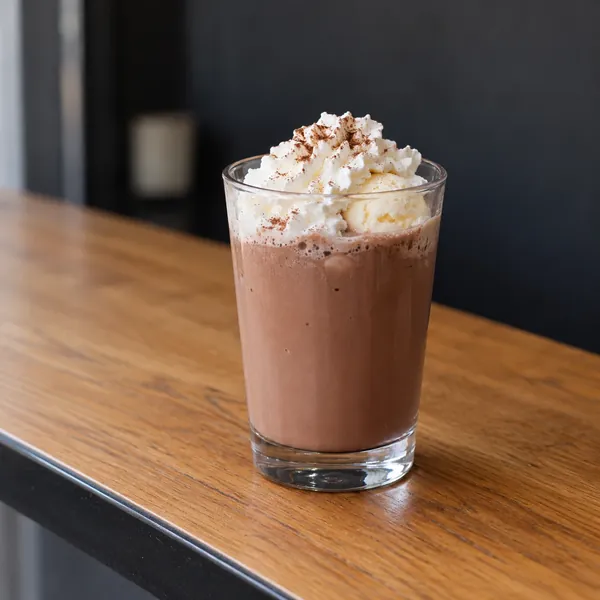 Eisschokolade im hohen Glas mit Sahne und Schokoladentopping